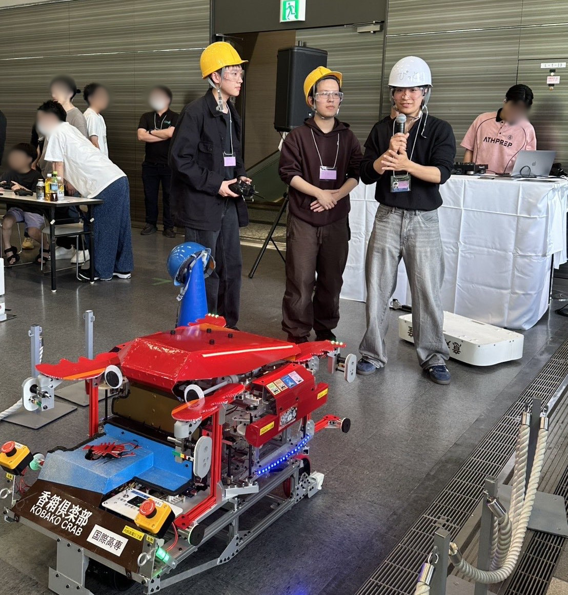 ステージ脇でロボットの説明をする学生